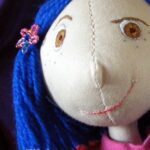 Pinterest pin for the Coraline doll, with a close up image of her cheeky face. I am quite pleased with the layout of this pin!