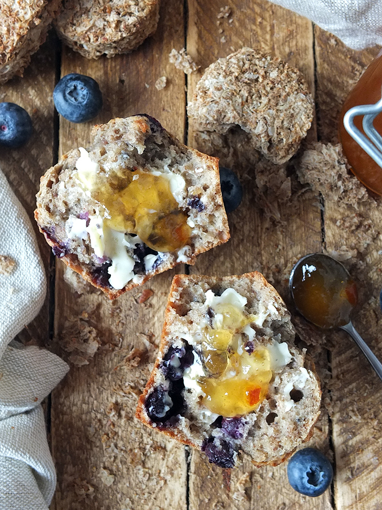 Photo of a halved blueberry weetabix muffin with butter and marmalade on it. 