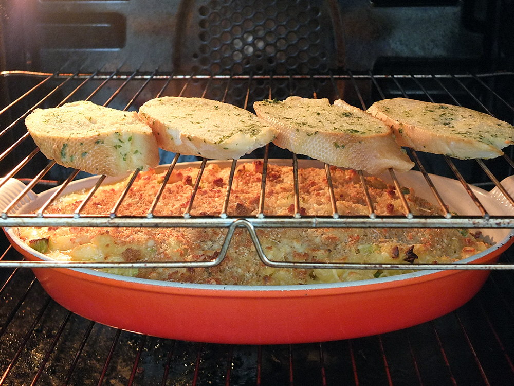 Garlic toast in the oven above macaroni and cheese