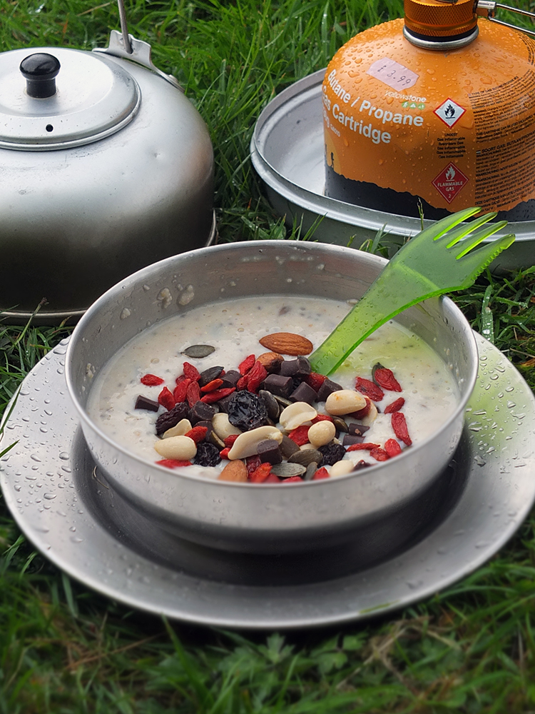 Image of DIY Porridge Sachets for Bikepacking or camping prepared in a camping bowl. It's raining.