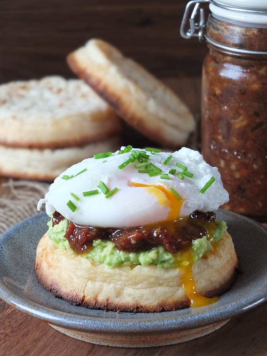 Another photo of homemade bacon jam on a toasted, buttered crumpet with smashed avocado topped with a perfectly poached runny egg. No seriously, that egg drip is to die for.