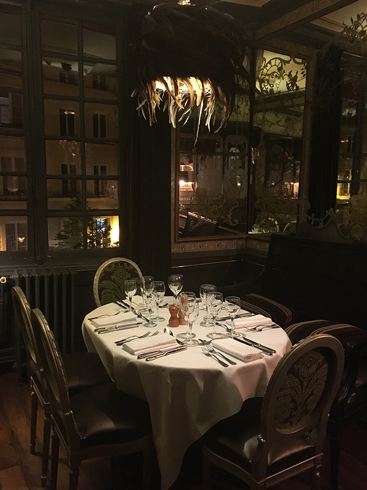 Dark, moody image of a set table in Pharamond, Paris.
