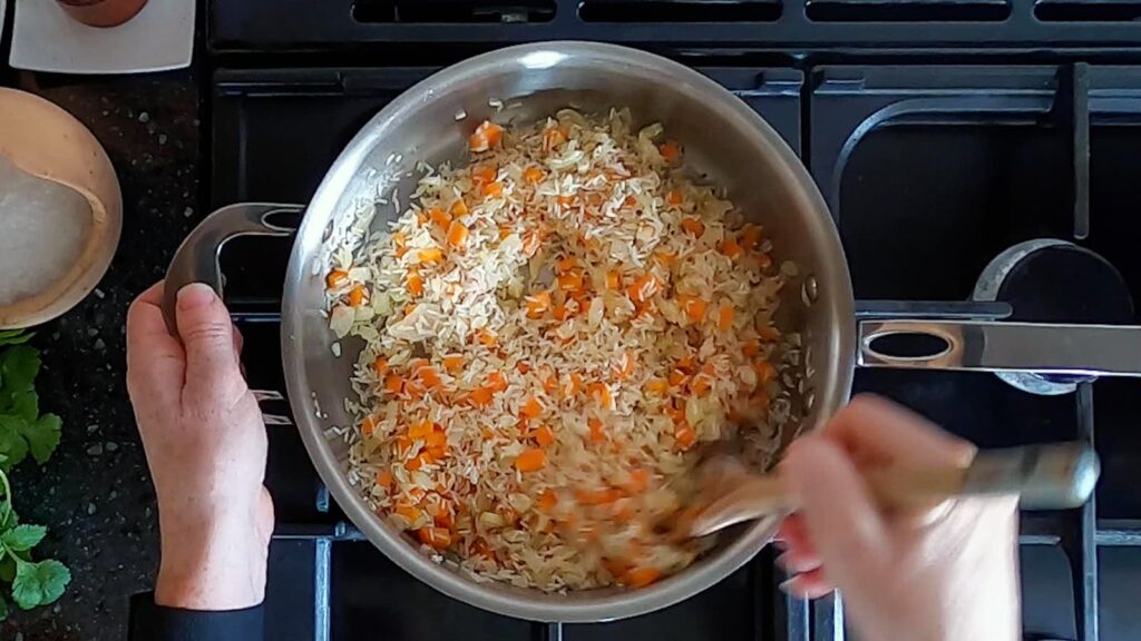 Image of saute pan with white rice toasted until golden.