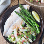 Picture of salsify with white fish, asparagus and a lemon wedge.