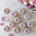 In this easy recipe, lemon zest, lemon extract and lavender flowers are combined to make a delicious, fluffy, moist, perfectly baked doughnut with a lavender icing sugar glaze. #doughnuts #bakeddoughnuts #lavender #lemondoughnut #lemondonut #bakeddonut