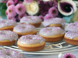 In this easy recipe, lemon zest, lemon extract and lavender flowers are combined to make a delicious, fluffy, moist, perfectly baked doughnut with a lavender icing sugar glaze. #doughnuts #bakeddoughnuts #lavender #lemondoughnut #lemondonut #bakeddonut