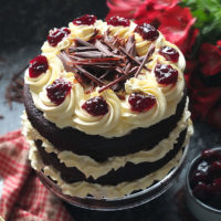 Layers of rich chocolate cake drizzled with cherry brandy sandwiched together with sweetened whipped cream and black cherry conserve. The cake is finished with more cream and some dark chocolate curls. #chocolate #chocolatecake #blackforestcake #baking