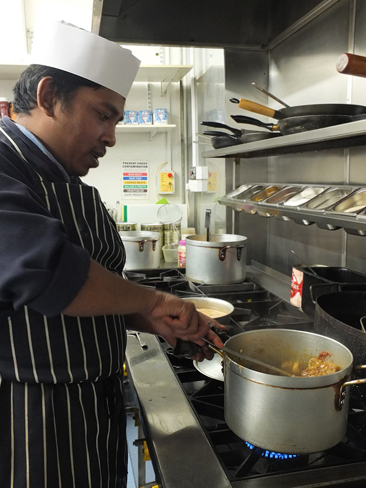 Chef Shirazul Islam from the Bengal Spice Indian Takeaway in Lerwick, Shetland, holding a lamb and spinach curry