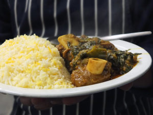 Chef Shirazul Islam from the Bengal Spice Indian Takeaway in Lerwick, Shetland, holding a lamb and spinach curry