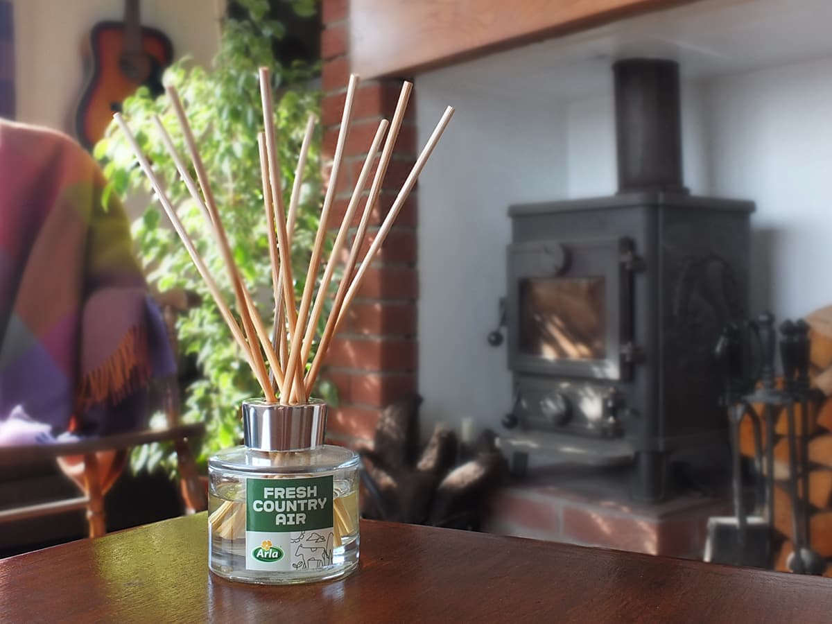 image of the limited edition room fragrance by Arla sitting on table with country fireplace in background