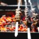 Image of a recipe for lamb skewers cooking on a barbecue.