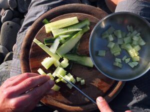 Photo of man chopping cucumber for tzatziki.