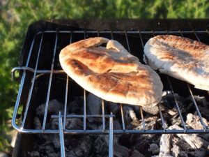 Image of pitta bread grilling on the barbecue.