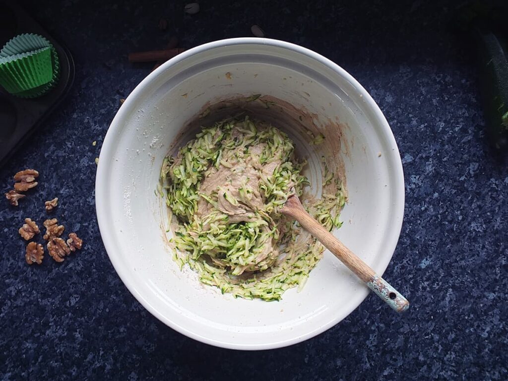 Image of cupcake batter in mixing bowl with grated courgettes.