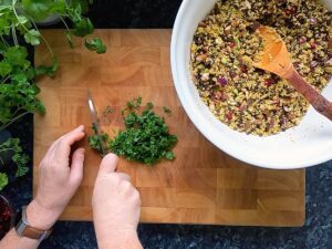 Photo of hands chopping herbs to go into jewelled couscous.