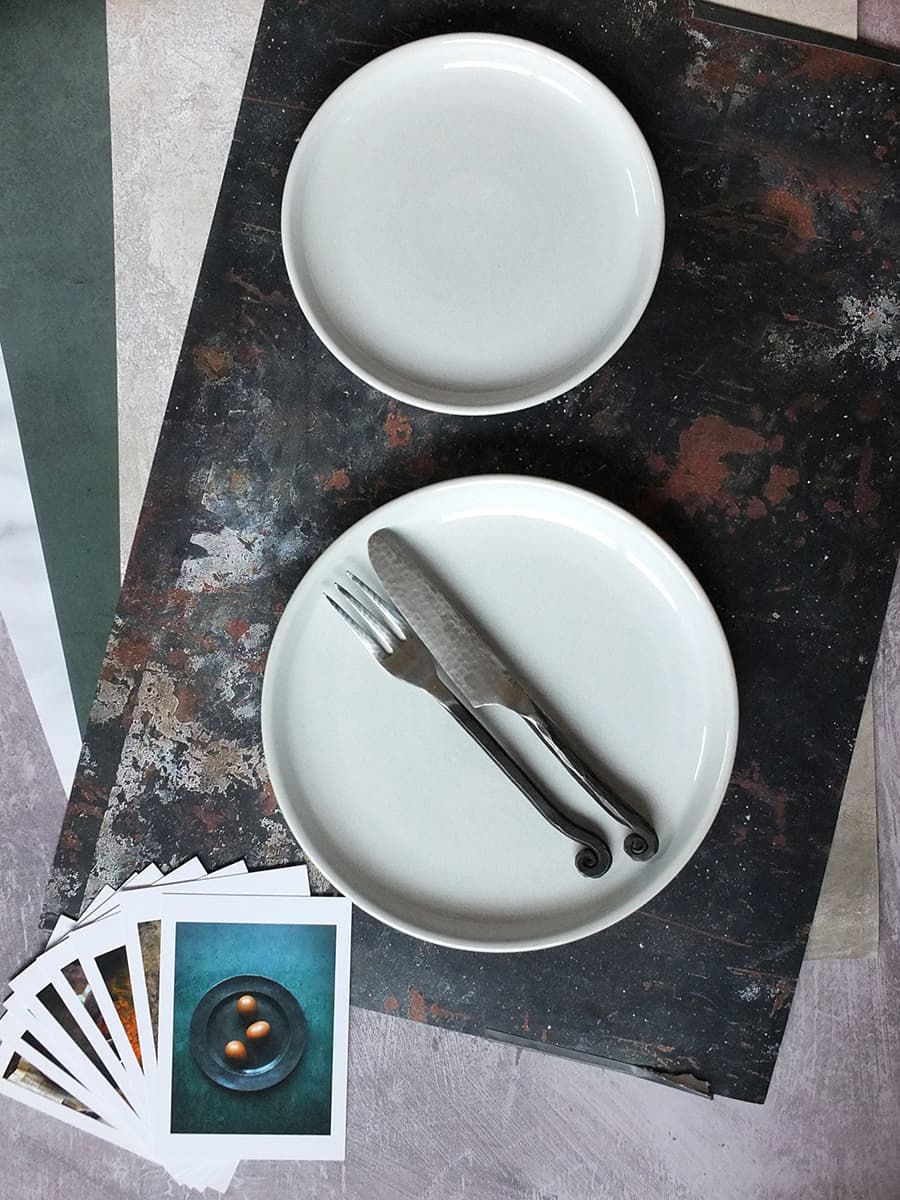 Photo of food photography backdrops in the Foodie Bag with a large dinner plate and small side plate for size comparison.