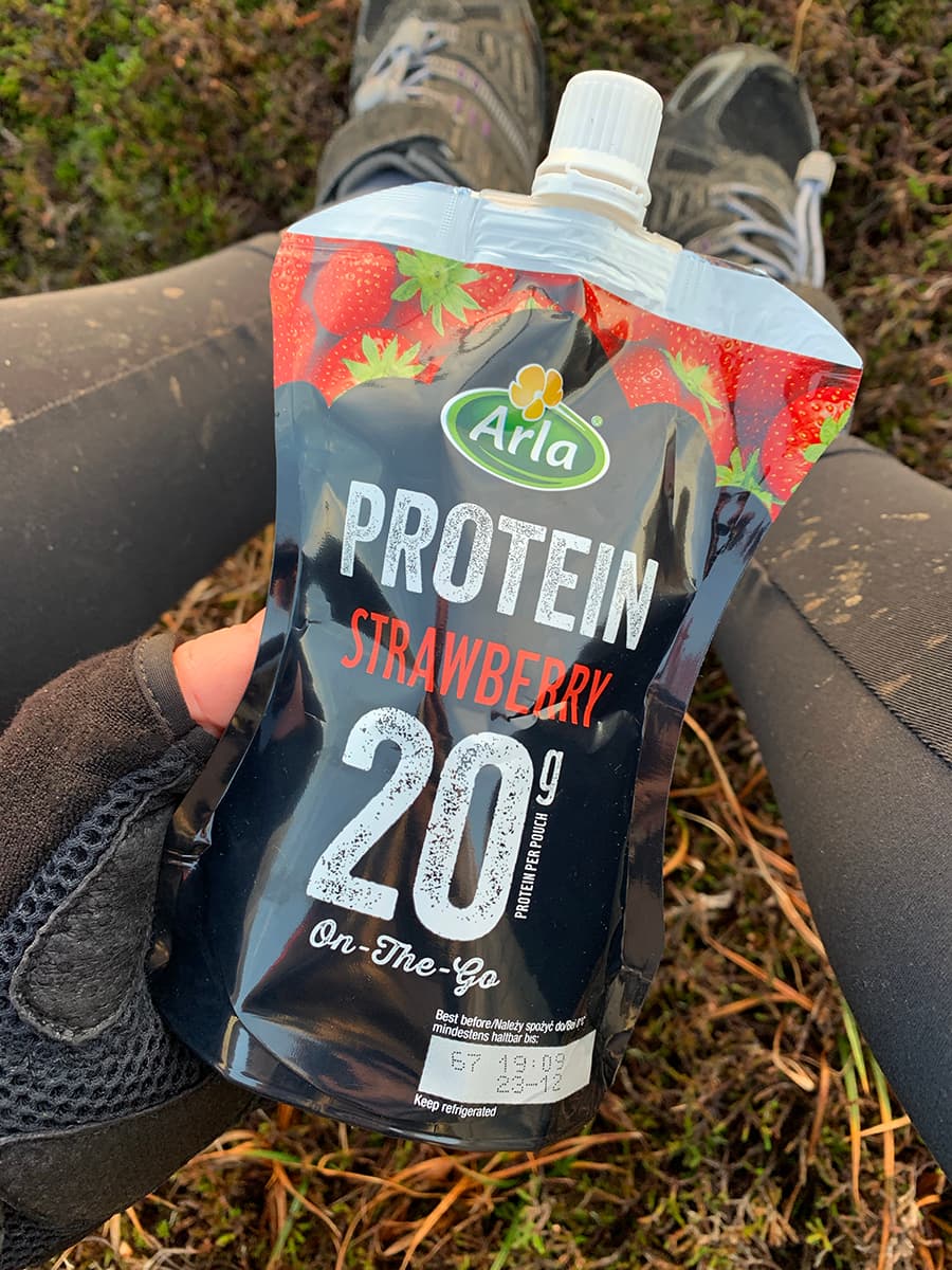 Image of Arla Protein 20 pouch and muddy biking leggings in the background.