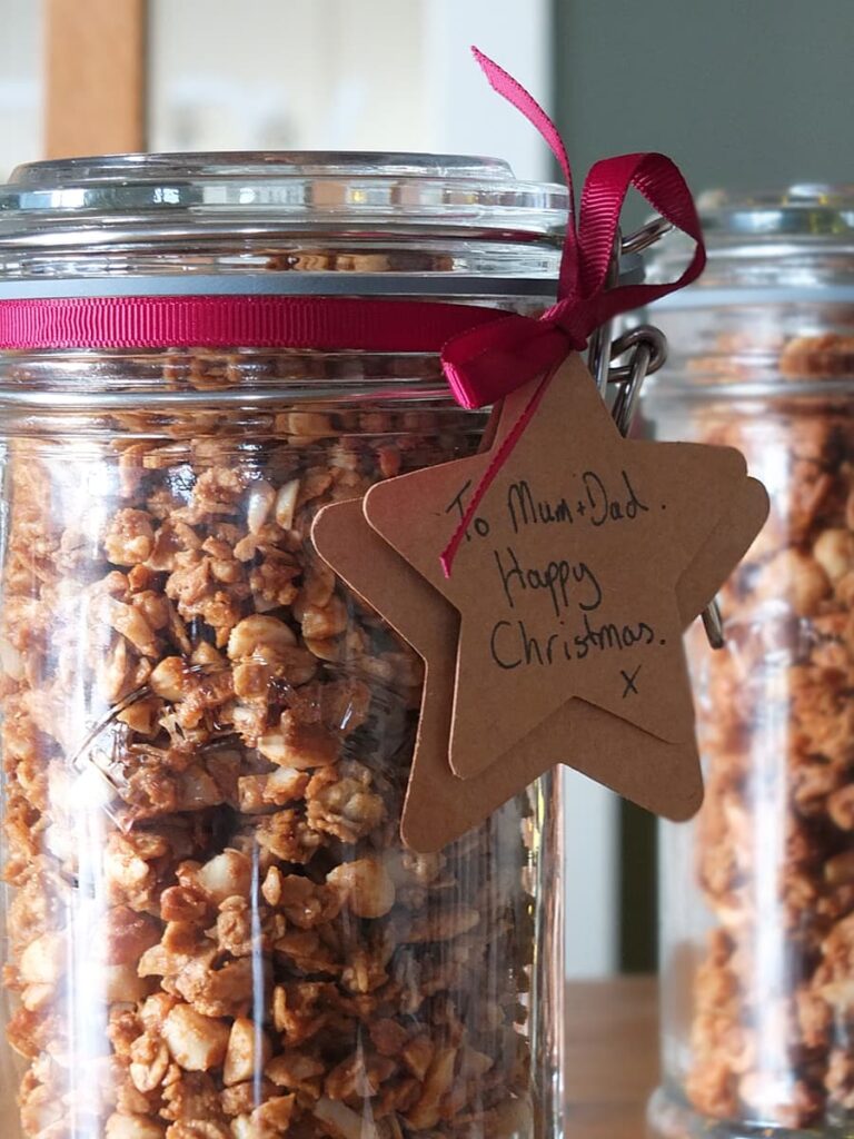 Close up image of a jar of peanut butter granola with gift tag.