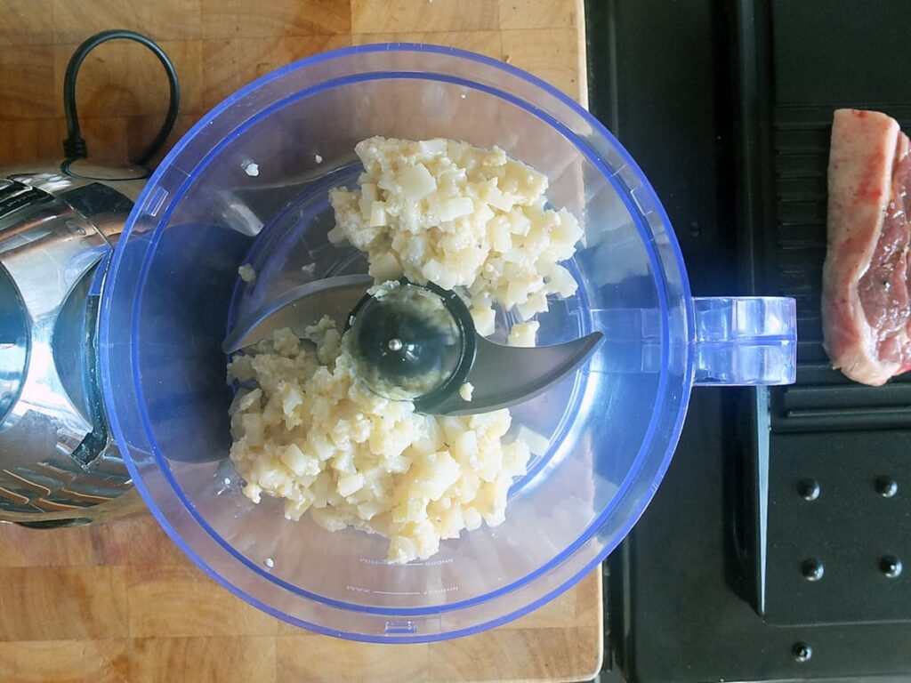 Image of cooked celeriac in food processor.