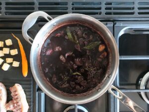 Top down image of red wine jus reducing in saute pan.