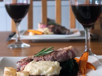 Image of a square white dinner plate with lamb leg steaks, celeriac puree and red wine jus for a romantic meal in.