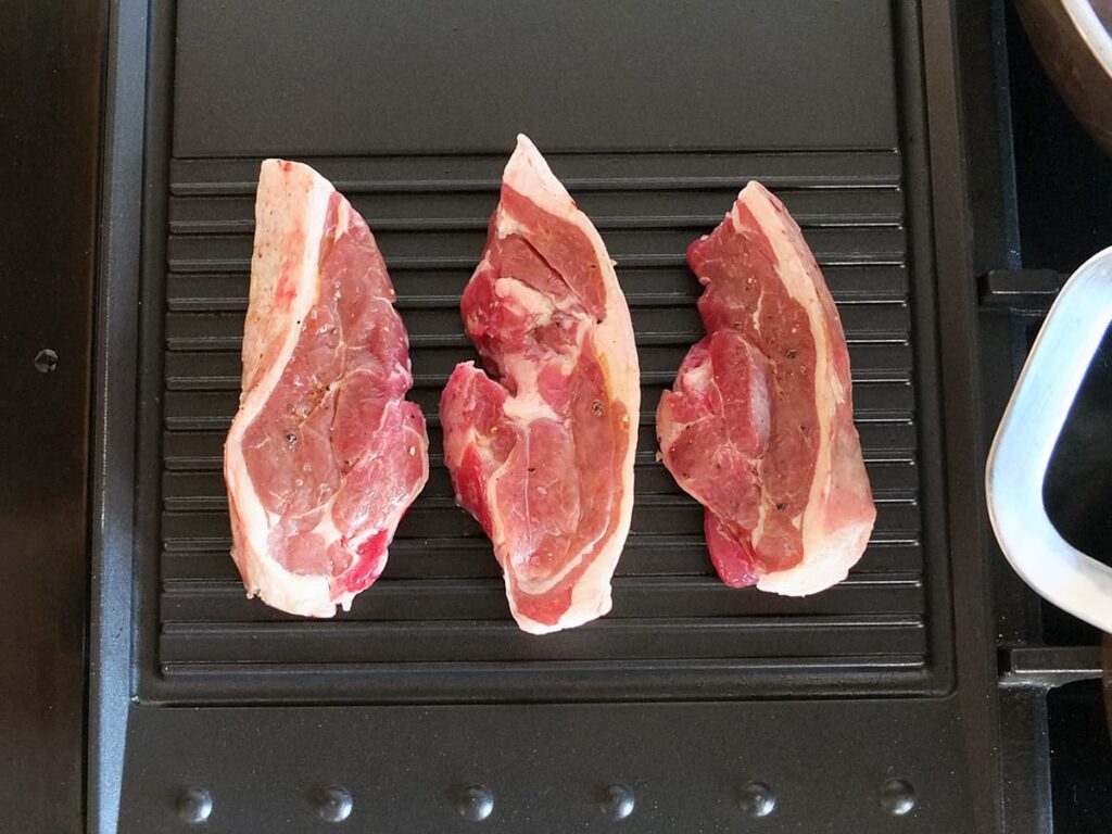 Image of lamb rump steaks cooking on Rangemaster griddle pan.