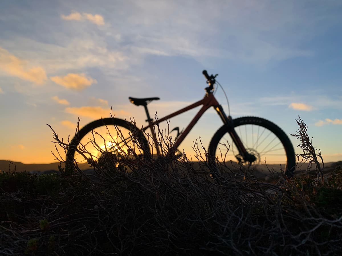 Silhouette of a mountain bike with the sunset in the background.