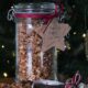 Image of large glass jar filled with peanut butter granola tied with a dark burgundy ribbon and a natural paper tag reading 'To Mum and Dad, Happy Christmas!'