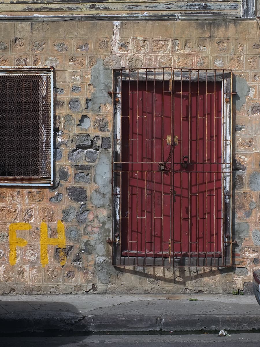 Image of a burgundy door behind a locked grill in St. Kitts. 