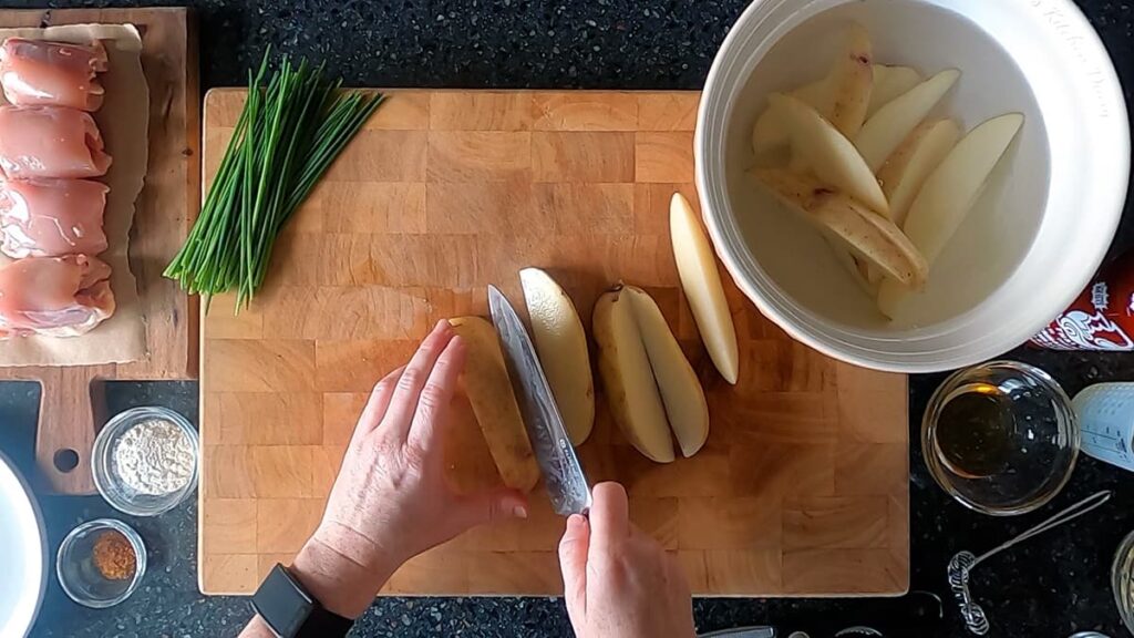 Top down image of potato wedges soaking in cold water.