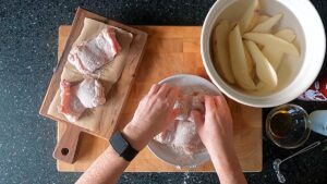 Image of chicken thighs dredged in seasoned flour.