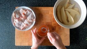 Image of hands mixing the spicy honey glaze in a small glass bowl.