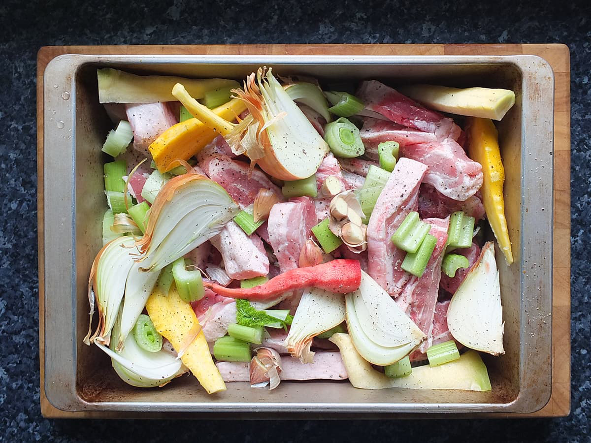 Image of pork and vegetables ready to be roasted to make pork stock from scratch.