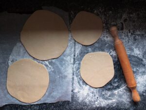 Top down image of hot water crust pastry rolled out with a lovely wooden rolling pin to the right hand side.