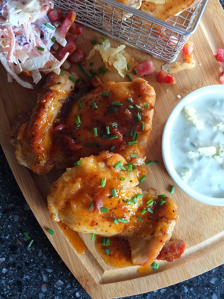 Close up image of spicy honey glazed chicken thighs with sauce dripping down the sides.