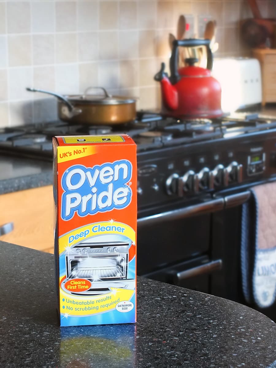 Image of the box of Oven Pride on the kitchen counter top with a Rangemaster oven blurred in the background.