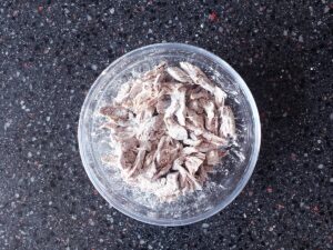 Image of shredded lamb coated in cornflour in a small bowl.