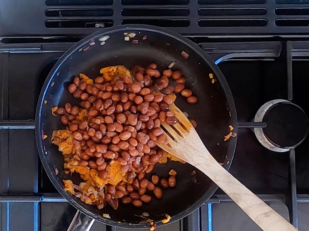 Photo of tinned borlotti beans in a frying pan.