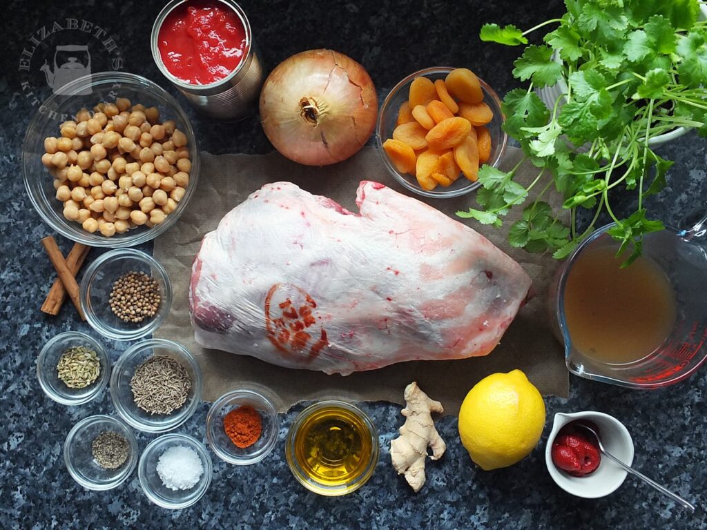 Photo of a shoulder of lamb and all the ingredients needed for this Moroccan-style slow cooked lamb shoulder recipe.