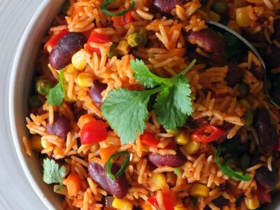 Top down image of spicy Mexican rice garnished with fresh coriander leaves.