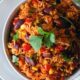 Top down image of spicy Mexican rice garnished with fresh coriander leaves.