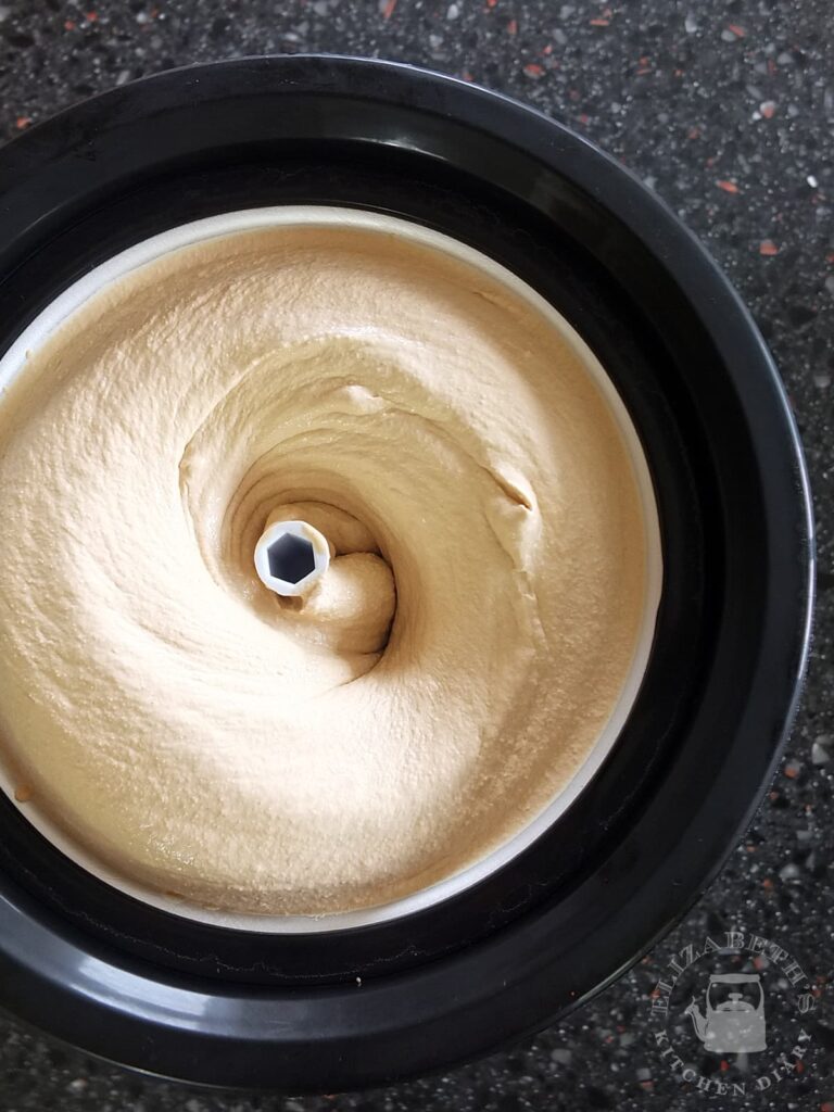Top down image of freshly churned coffee ice cream in an ice cream machine.