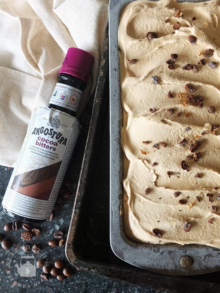 Top down image of coffee ice cream in a bread tin with a bottle of Angostura cocoa bitters to the side.