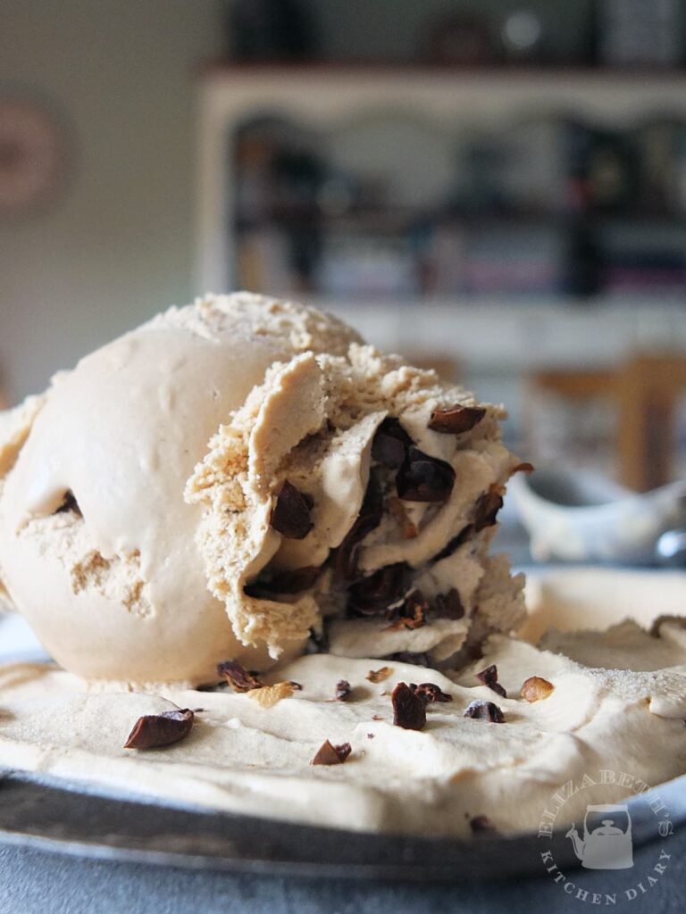 Close up side view of a scoop of coffee ice cream.