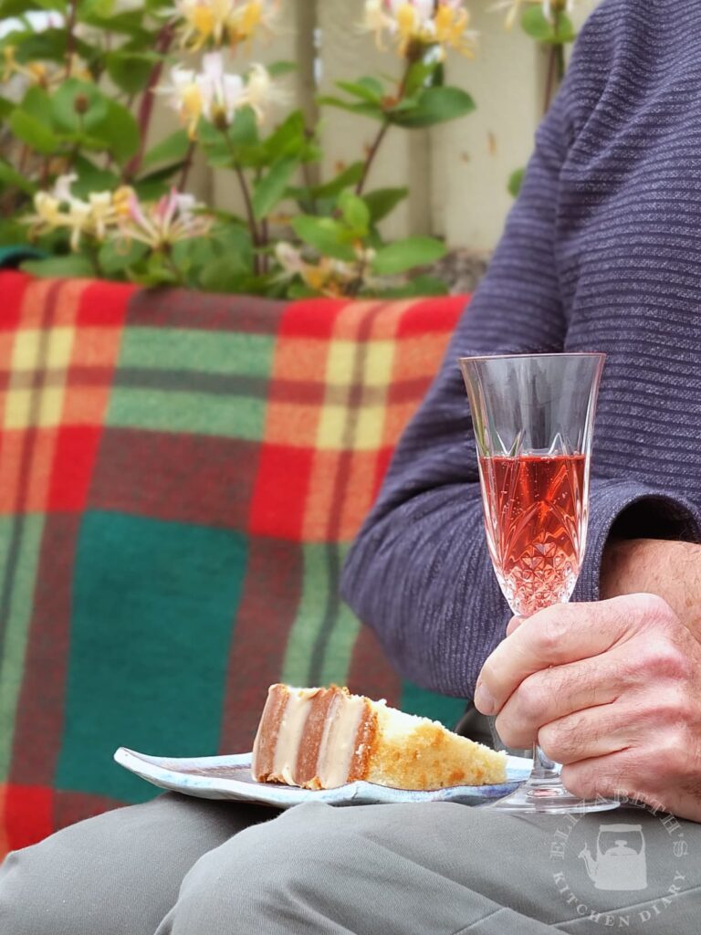 Image of a slice of cake on a plate in a man's lap.