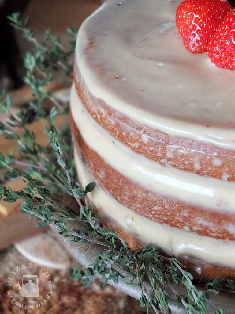 A close up image of the three layers of naked frosted birthday cake.