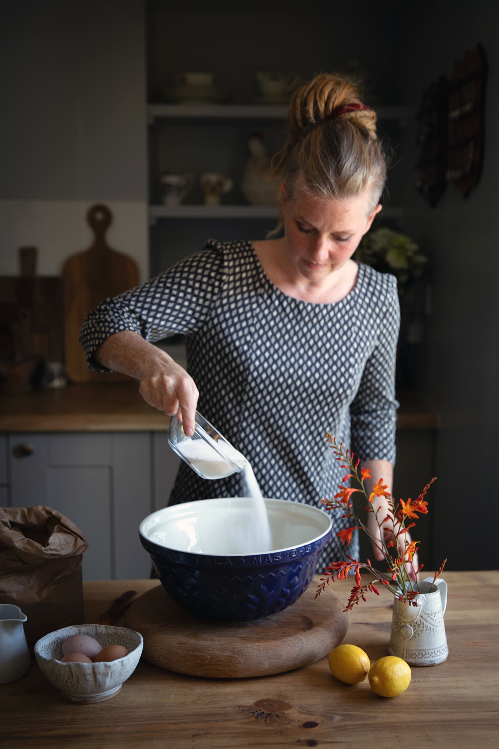 Image of Elizabeth Atia making a cake in the Aald Harbour Hoose, Shetland. Photograph by Misa Hay from Shetland Wool Adventures. 
