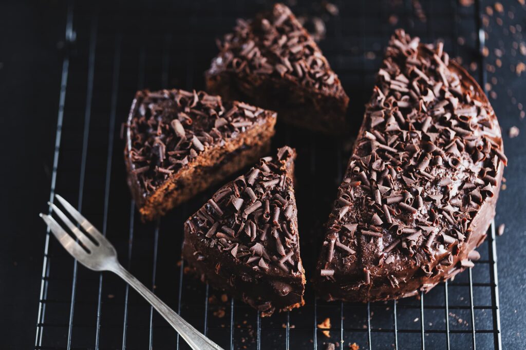 Photo of a rich, dark chocolate devil's food cake with frosting and plenty of chocolate sprinkles. 