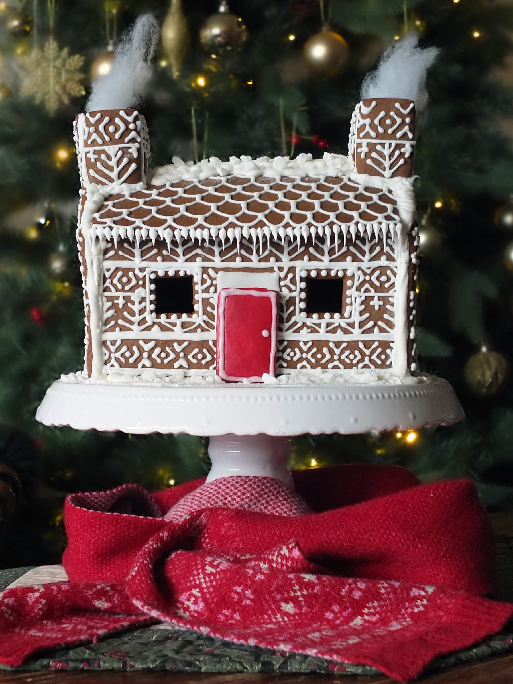 Image of a completed Shetland Croft Gingerbread house decorated with Fair Isle knitting designs and a bright red front door.