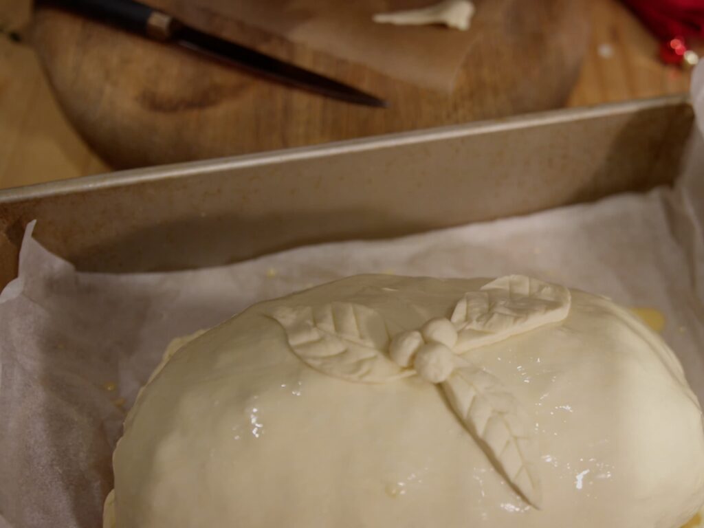 Image of holly leaf and berry puff pastry decorations on top of turkey wellington.